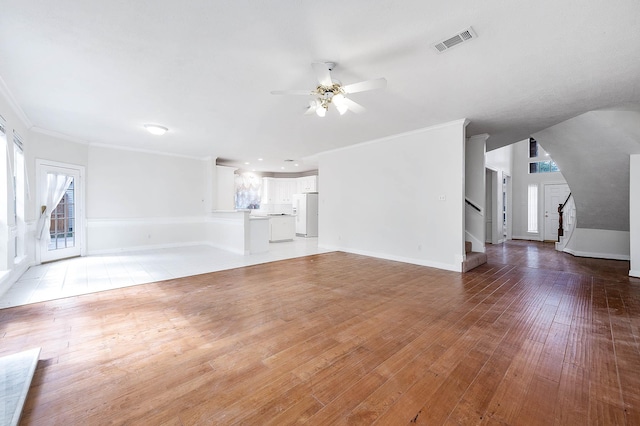 unfurnished living room with ceiling fan, wood-type flooring, and ornamental molding