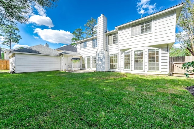 rear view of house with a lawn and a patio area