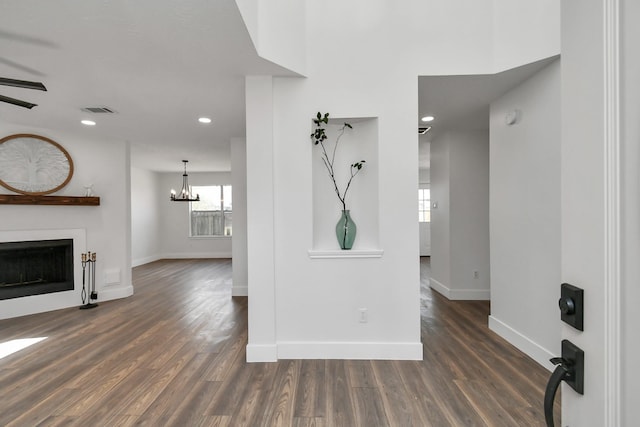 unfurnished living room featuring dark wood-type flooring and a notable chandelier