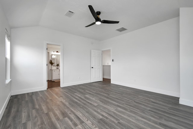 unfurnished bedroom with ensuite bath, ceiling fan, dark hardwood / wood-style flooring, and vaulted ceiling