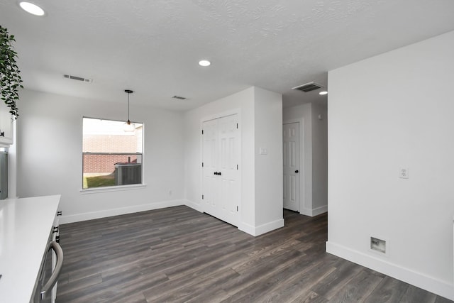 interior space featuring a textured ceiling and dark wood-type flooring