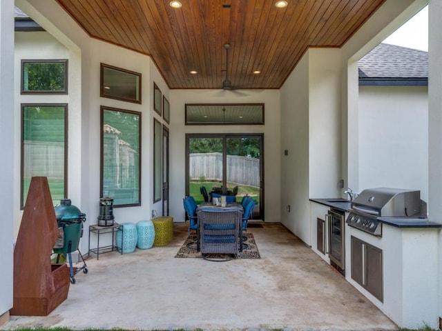 view of patio with an outdoor kitchen, area for grilling, ceiling fan, beverage cooler, and sink