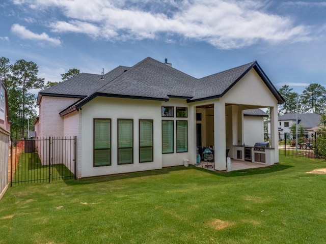 back of property with a patio, a lawn, and exterior kitchen