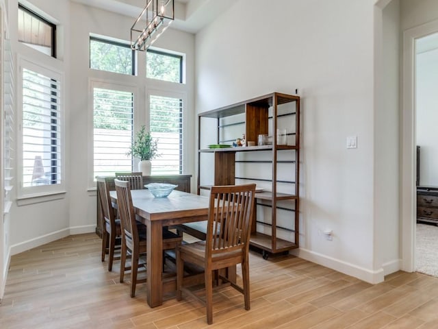 dining room with light wood-type flooring and a notable chandelier