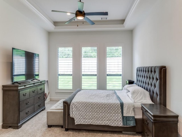 carpeted bedroom with ceiling fan and a raised ceiling