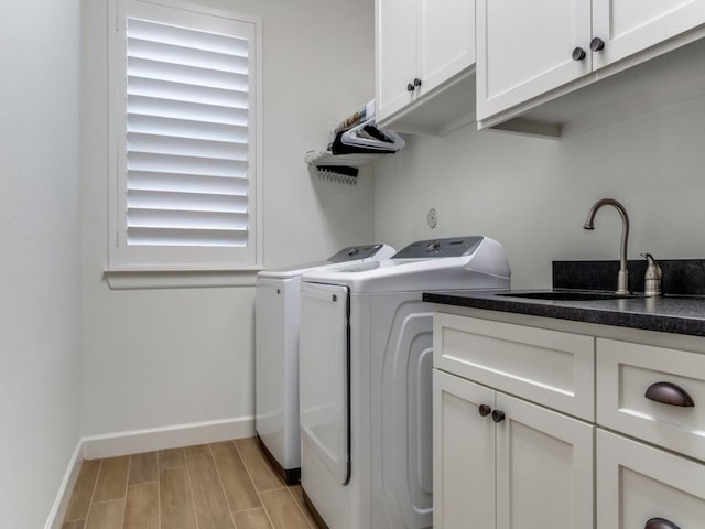 clothes washing area featuring cabinets, independent washer and dryer, sink, and a wealth of natural light