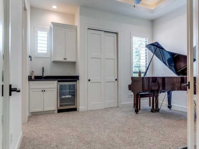 interior space with light colored carpet, wet bar, and beverage cooler