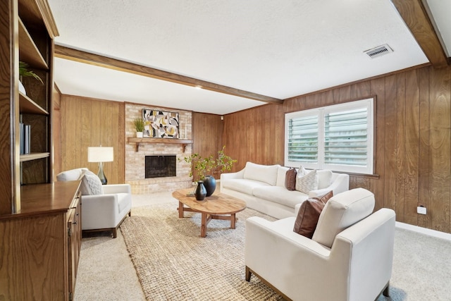 carpeted living room featuring beamed ceiling, a brick fireplace, and wood walls