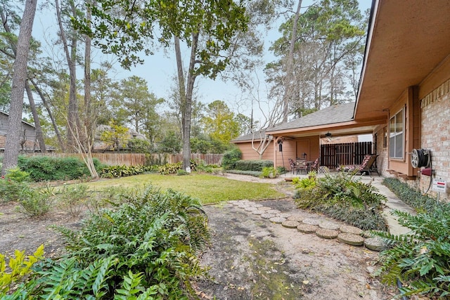 view of yard with ceiling fan and a patio area