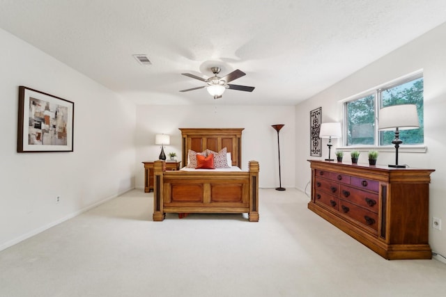 carpeted bedroom featuring ceiling fan and a textured ceiling