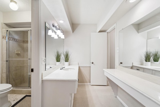 bathroom with vanity, a shower with shower door, and toilet