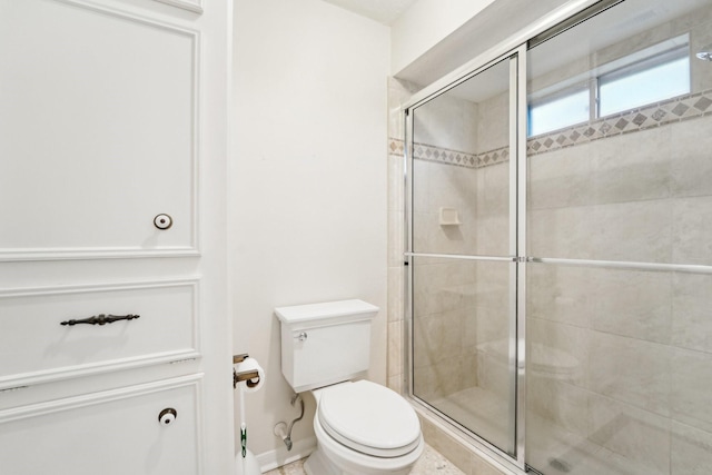 bathroom with toilet and a shower with door