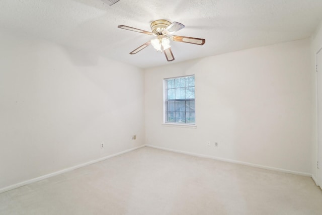 carpeted spare room featuring a textured ceiling and ceiling fan