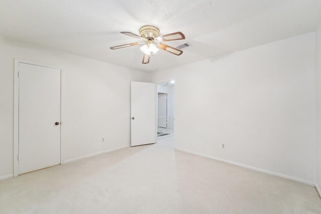 carpeted spare room featuring ceiling fan