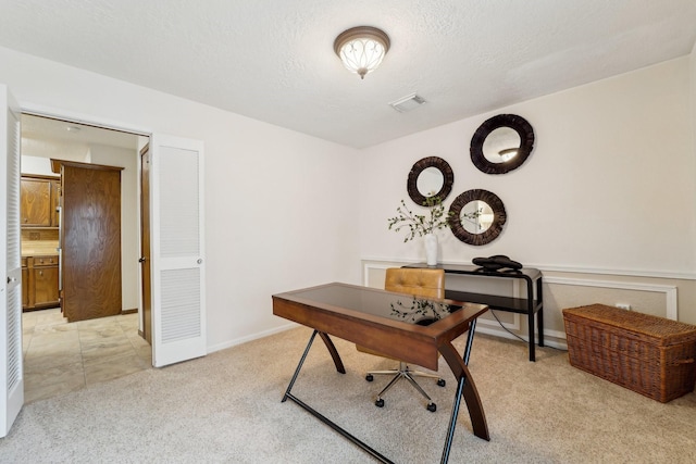 home office with light carpet and a textured ceiling