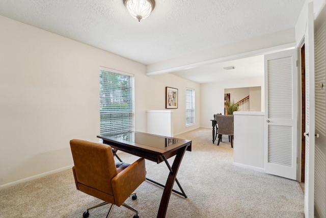 home office featuring a textured ceiling, beam ceiling, and light carpet