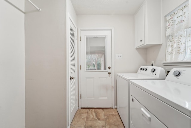 washroom with cabinets and washing machine and clothes dryer