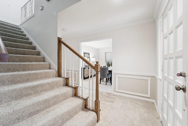 stairway featuring carpet and ornamental molding