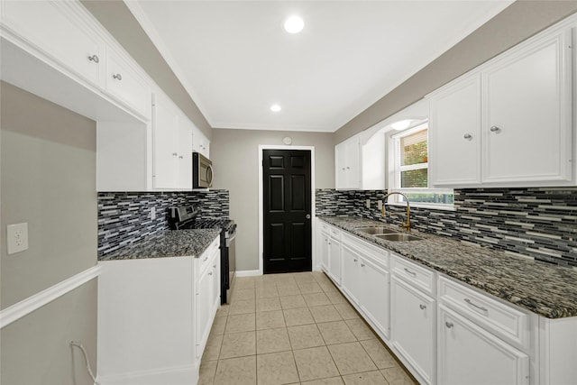 kitchen with white cabinets, sink, stainless steel stove, and dark stone countertops