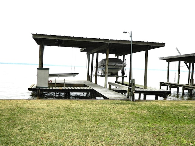 view of dock featuring a lawn and a water view