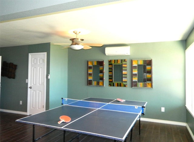 game room featuring an AC wall unit, ceiling fan, and dark hardwood / wood-style flooring