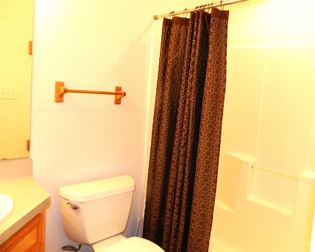 bathroom with curtained shower, vanity, and toilet