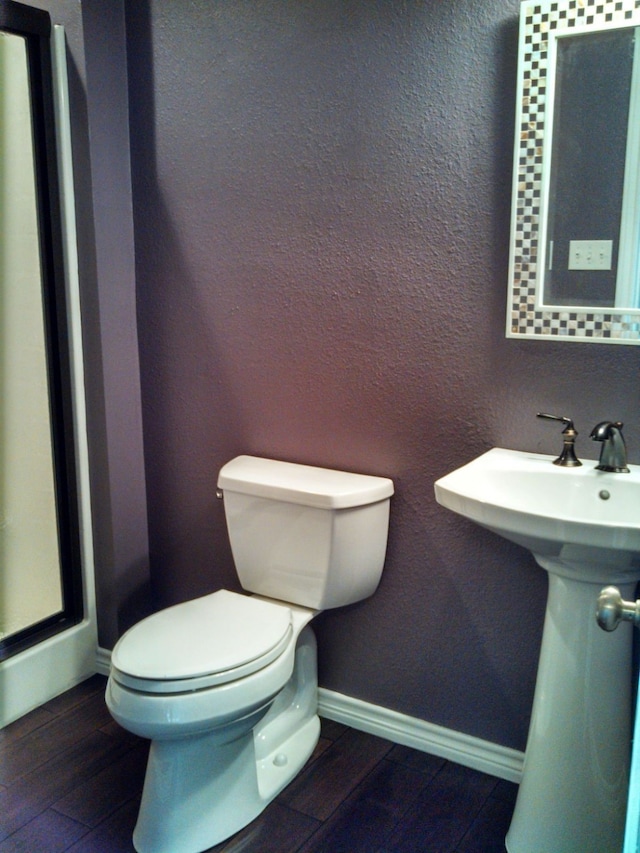 bathroom with wood-type flooring and toilet