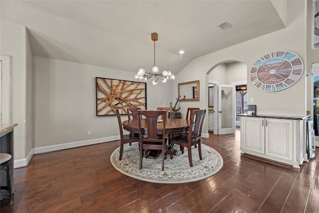 dining room featuring lofted ceiling, dark wood-type flooring, and a chandelier