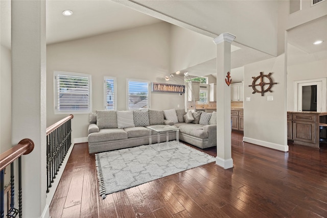 living room with decorative columns, high vaulted ceiling, and dark hardwood / wood-style floors