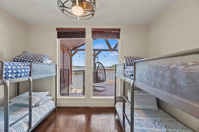 bedroom featuring a water view and dark wood-type flooring