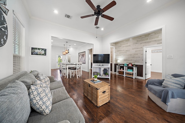 living room featuring dark hardwood / wood-style floors, ceiling fan, and crown molding