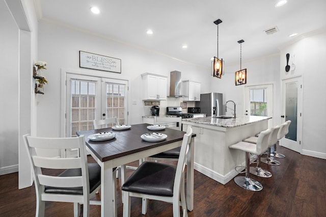 dining room featuring crown molding, a wealth of natural light, sink, and dark wood-type flooring