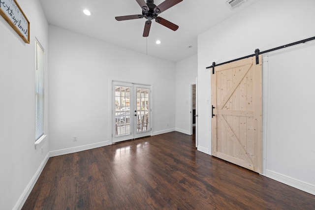 unfurnished bedroom with french doors, access to outside, ceiling fan, dark wood-type flooring, and a barn door