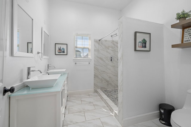 bathroom featuring tiled shower, vanity, and toilet