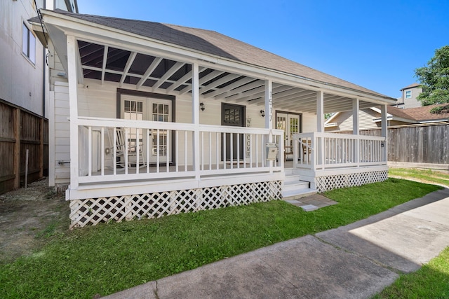 rear view of property with a porch and a lawn