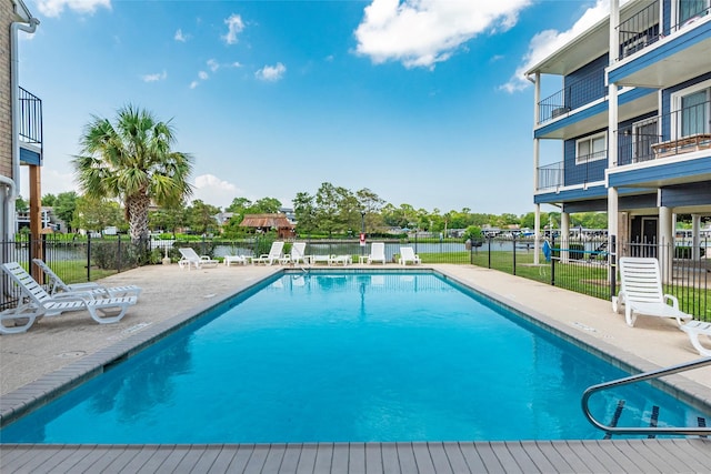 view of swimming pool featuring a water view and a patio