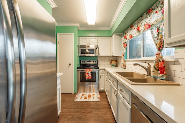 kitchen with white cabinets, backsplash, sink, and appliances with stainless steel finishes