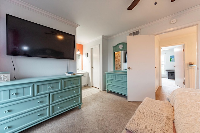 carpeted bedroom with ensuite bathroom, ceiling fan, and ornamental molding