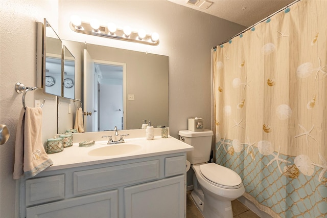 bathroom with a textured ceiling, vanity, and toilet