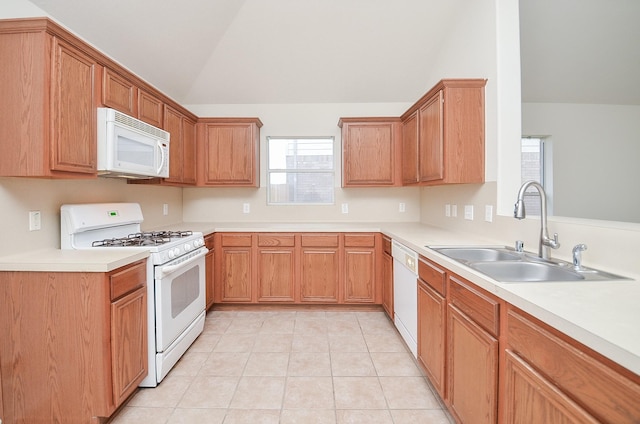 kitchen featuring light tile patterned floors, white appliances, lofted ceiling, and sink