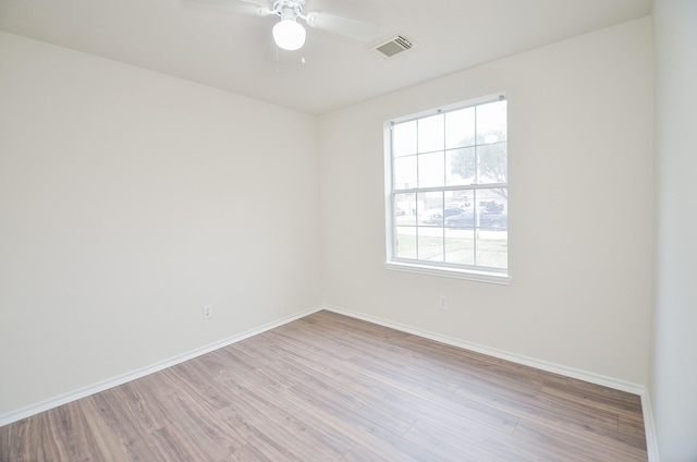 empty room with ceiling fan and light hardwood / wood-style floors