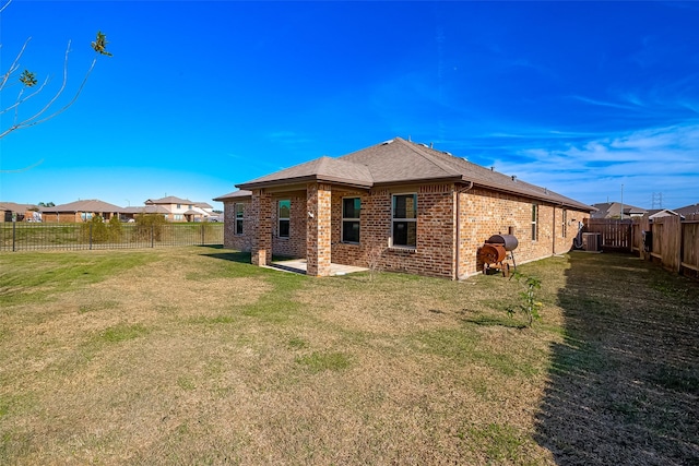 rear view of property featuring a lawn and a patio area