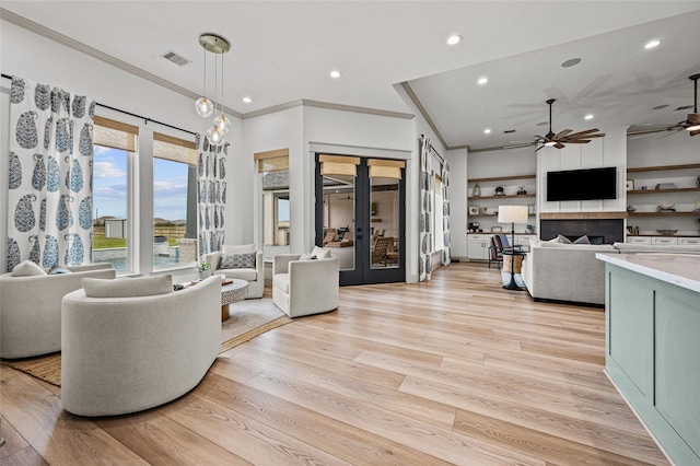 living room with ornamental molding, ceiling fan, light hardwood / wood-style flooring, and french doors