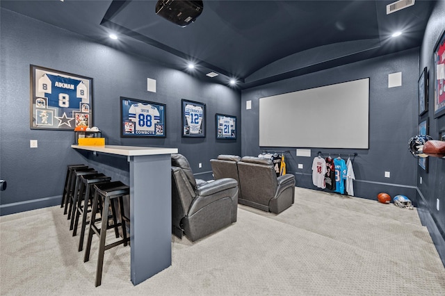 carpeted home theater with indoor bar, brick ceiling, and vaulted ceiling