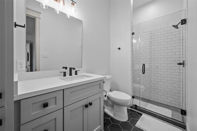 bathroom with toilet, vanity, tile patterned floors, and walk in shower