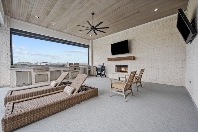 view of patio / terrace featuring a large fireplace, an outdoor kitchen, grilling area, and ceiling fan