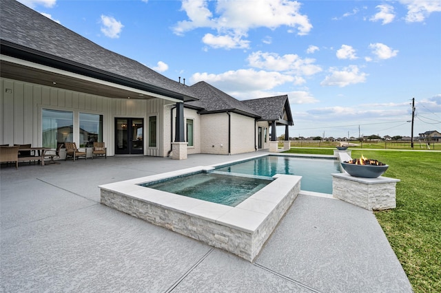 view of pool with a fire pit, a yard, an in ground hot tub, and a patio