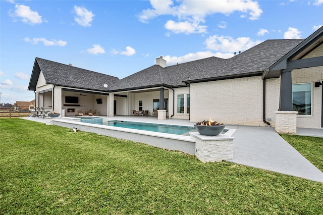 back of property with ceiling fan, a yard, and a patio area