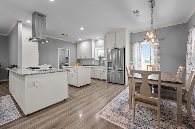 kitchen with white cabinets, decorative light fixtures, island exhaust hood, stainless steel refrigerator with ice dispenser, and a kitchen island