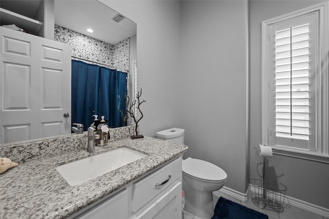 bathroom with toilet, vanity, tile patterned flooring, and curtained shower